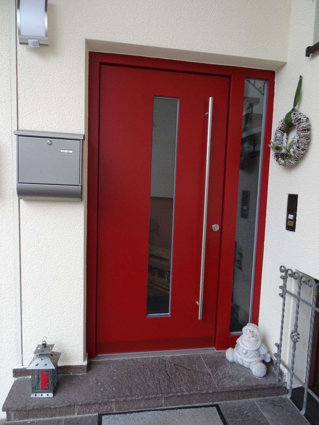 Haustürelement in rot mit Edelstahl Griffstange, Lichtausschnitt und schmalem Seitenteil (Schemmerhofen)