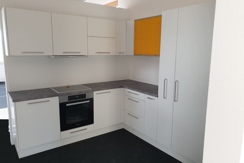 Küche in weiß mit Arbeitsplatte in grau und Oberschrank gelb (Schemmerhofen)